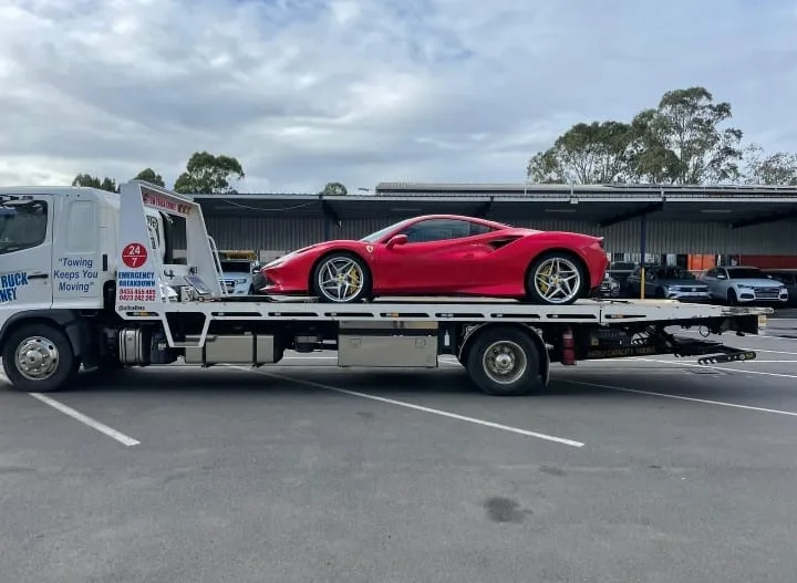 Red sports car on tow truck